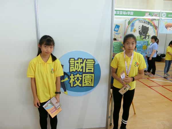 新竹市政府廉政志工協助108廉潔教育校園宣導專車系列「閱讀好品格•廉政心活力」設攤活動學童與誠信校園刊板合照