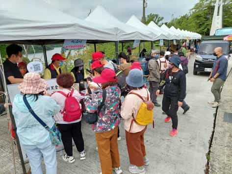 新竹縣政府政風處廉政志工協助辦理客家桐花季攤位反賄選宣導現場民眾掃描QRCode